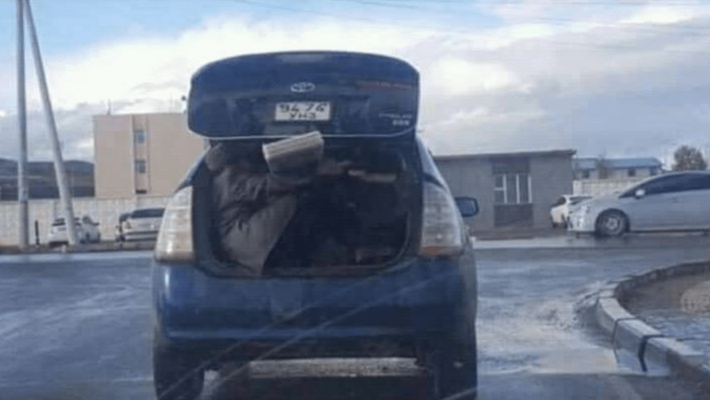 Only in Mongolia 16: Ein Mitfahrer hält eine Holzplanke fest auf der Fahrt