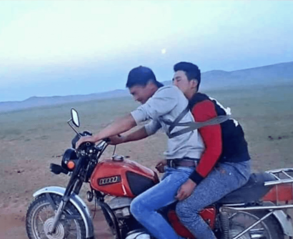 Ein betrunkener wird auf dem Motorrad nach Hause gebracht