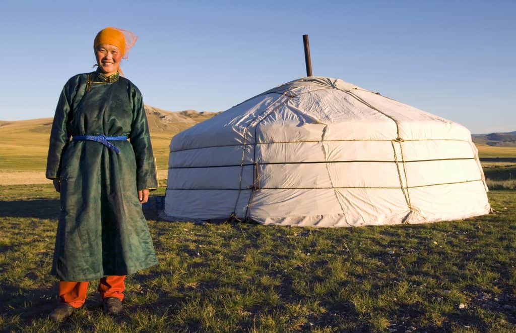 Frau in mongolischer Kleidung vor einer Jurte